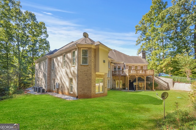 back of property with a wooden deck and a lawn