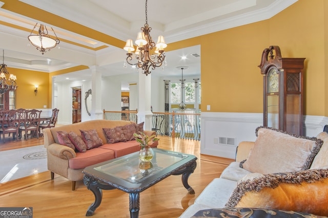 living room with crown molding, a tray ceiling, and light hardwood / wood-style floors