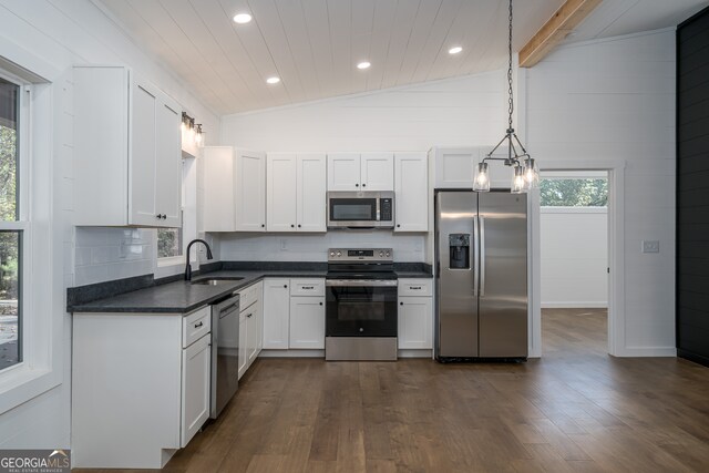 kitchen featuring pendant lighting, sink, dark hardwood / wood-style floors, appliances with stainless steel finishes, and white cabinetry