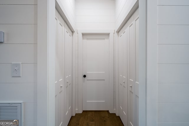 hall with wooden walls and dark hardwood / wood-style floors