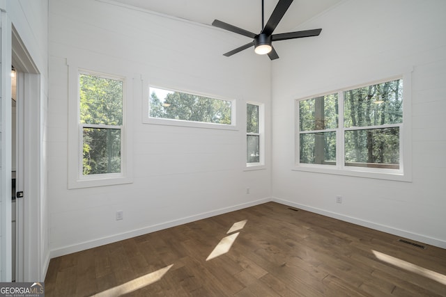 empty room with ceiling fan, dark hardwood / wood-style floors, and a healthy amount of sunlight