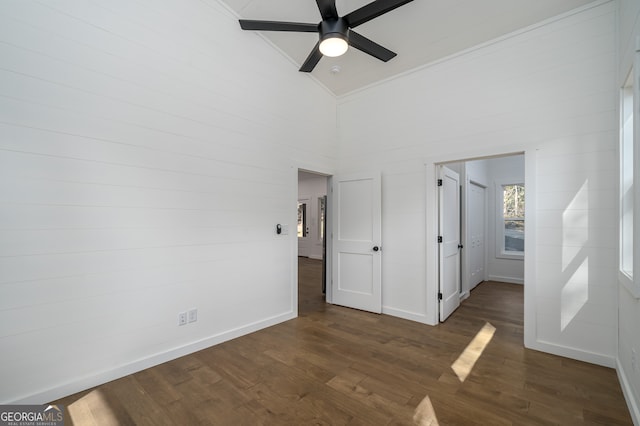 unfurnished bedroom with high vaulted ceiling, ceiling fan, dark wood-type flooring, and crown molding