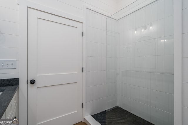 bathroom featuring a tile shower and vanity