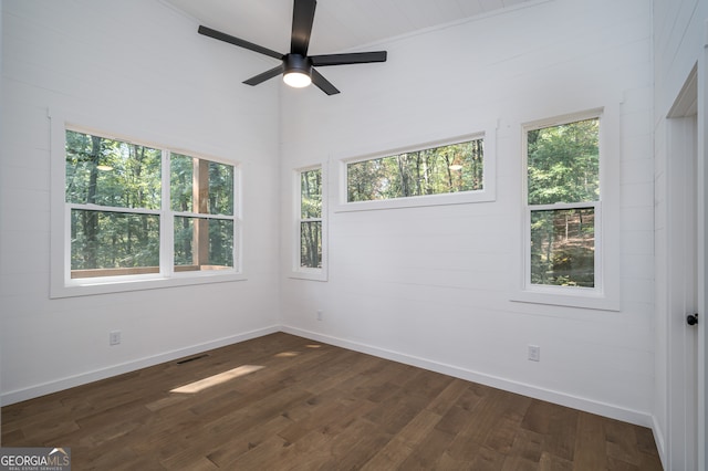 spare room featuring ceiling fan, plenty of natural light, and dark hardwood / wood-style floors