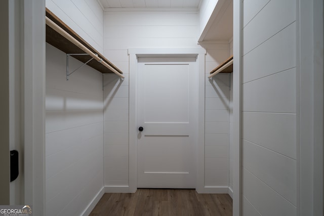 walk in closet with hardwood / wood-style flooring