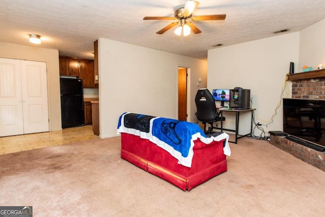 carpeted living room with a brick fireplace, a textured ceiling, and ceiling fan