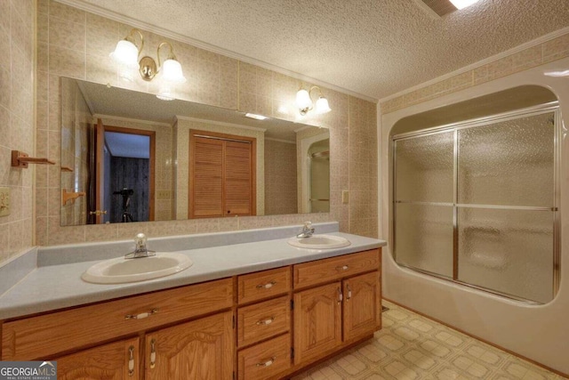 bathroom featuring tile walls, ornamental molding, vanity, and a textured ceiling