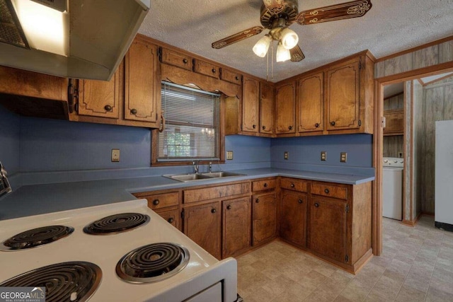 kitchen featuring extractor fan, sink, a textured ceiling, and washer / dryer