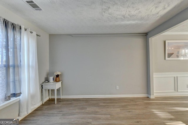 spare room with wood-type flooring and a textured ceiling