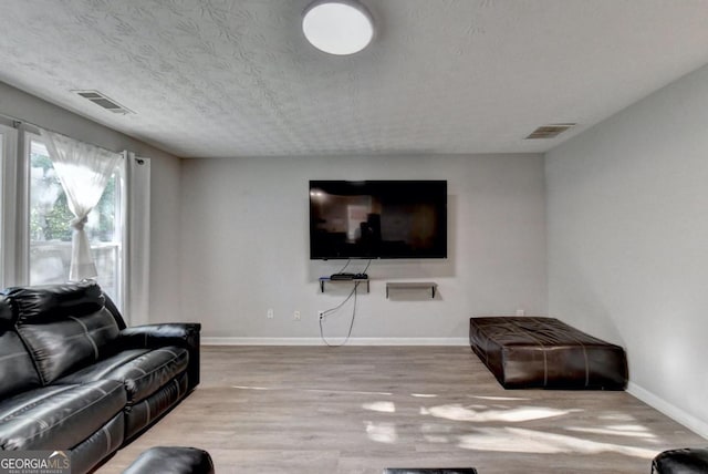 living room featuring a textured ceiling and light wood-type flooring