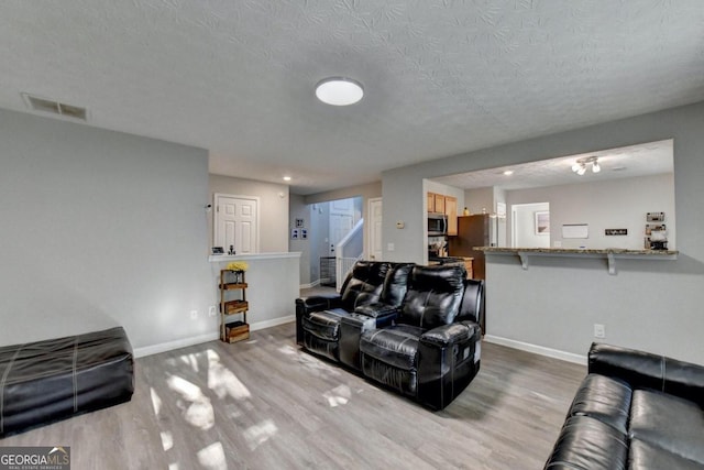 living room featuring hardwood / wood-style flooring and a textured ceiling