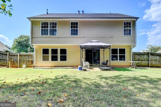 rear view of property with a gazebo, a yard, and a patio area