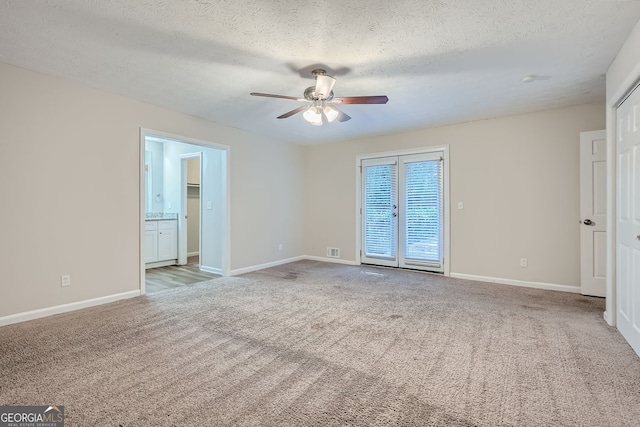 carpeted empty room with ceiling fan and a textured ceiling