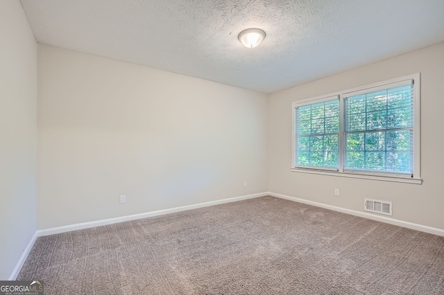 carpeted empty room with a textured ceiling