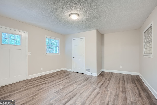 foyer with a textured ceiling and light hardwood / wood-style flooring