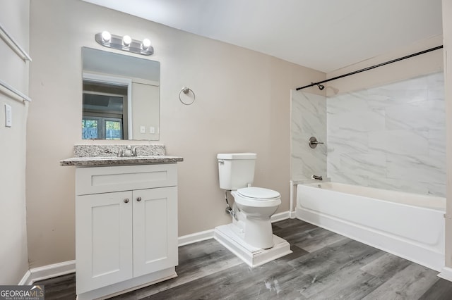 full bathroom featuring hardwood / wood-style floors, tiled shower / bath, vanity, and toilet