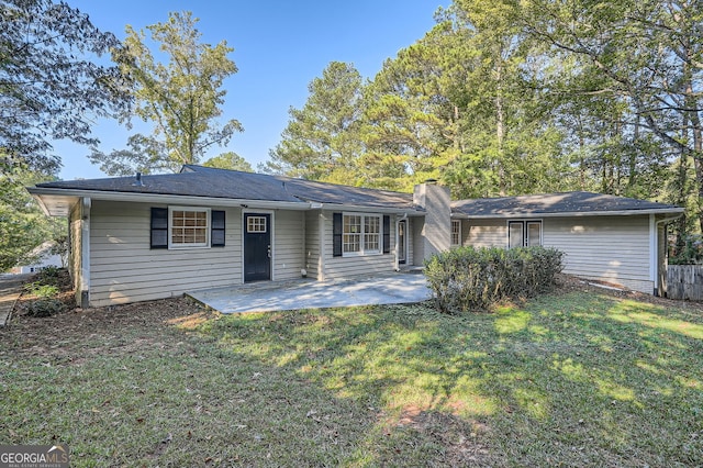 rear view of house with a yard and a patio