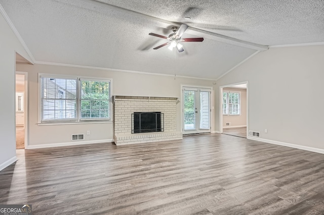 unfurnished living room with a brick fireplace, ceiling fan, dark hardwood / wood-style floors, vaulted ceiling with beams, and a textured ceiling