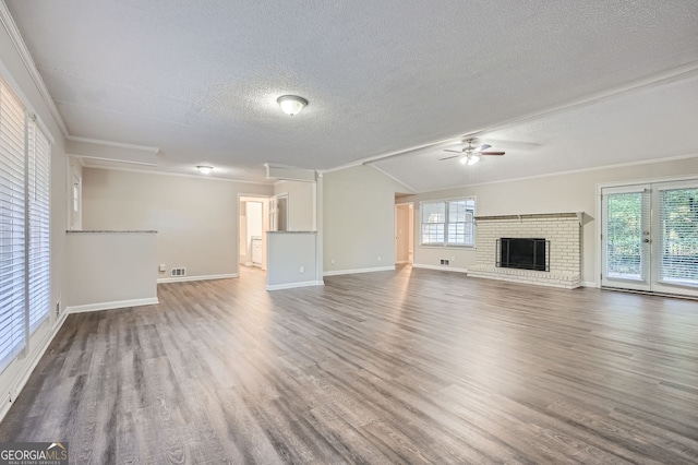 unfurnished living room with hardwood / wood-style flooring, a fireplace, ornamental molding, and a wealth of natural light