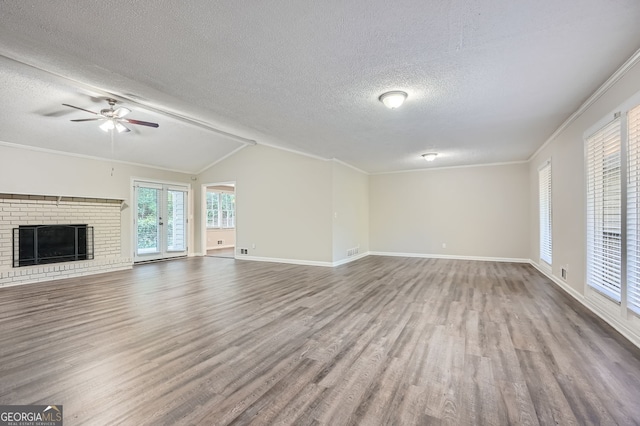 unfurnished living room featuring ceiling fan, hardwood / wood-style floors, a textured ceiling, and vaulted ceiling