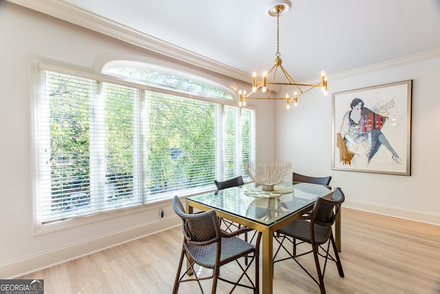 dining space featuring ornamental molding, a healthy amount of sunlight, a notable chandelier, and light hardwood / wood-style floors