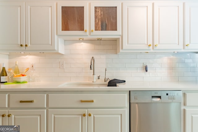 kitchen featuring dishwasher, decorative backsplash, sink, and white cabinetry