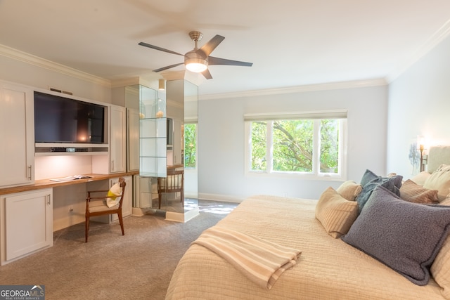 carpeted bedroom with ceiling fan, crown molding, and built in desk