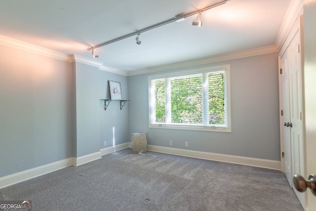 unfurnished room featuring dark carpet, crown molding, and track lighting