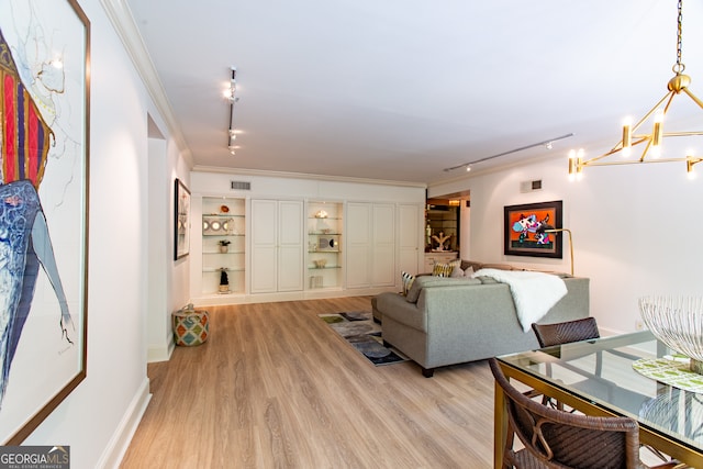 living room with crown molding, a chandelier, light wood-type flooring, and track lighting