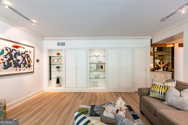 living room with light hardwood / wood-style floors, ornamental molding, and track lighting