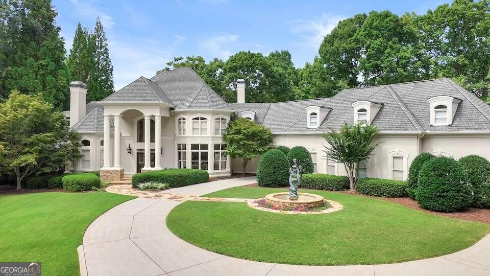 french country home with a front lawn