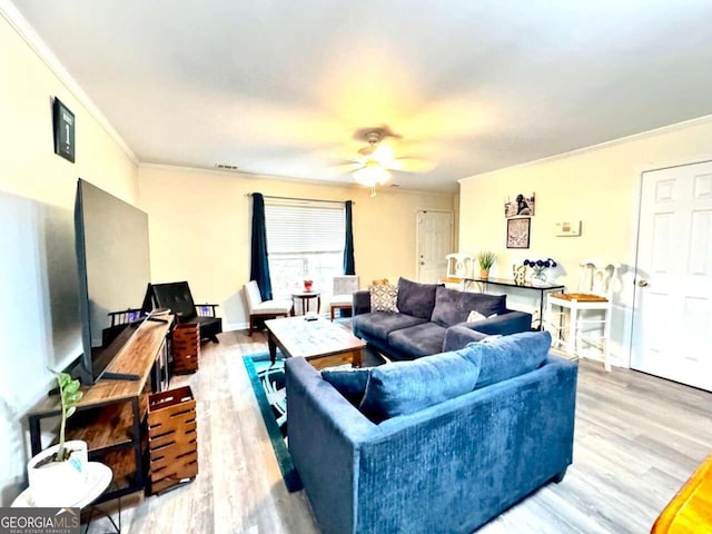 living room featuring crown molding, wood-type flooring, and ceiling fan