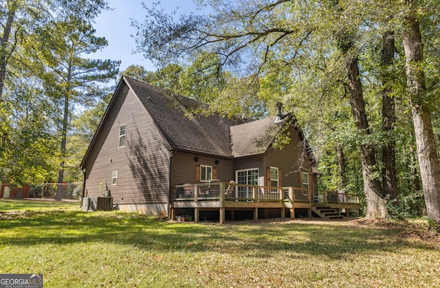 back of property featuring a lawn and a deck