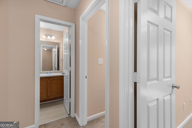 hallway featuring light wood-type flooring and sink