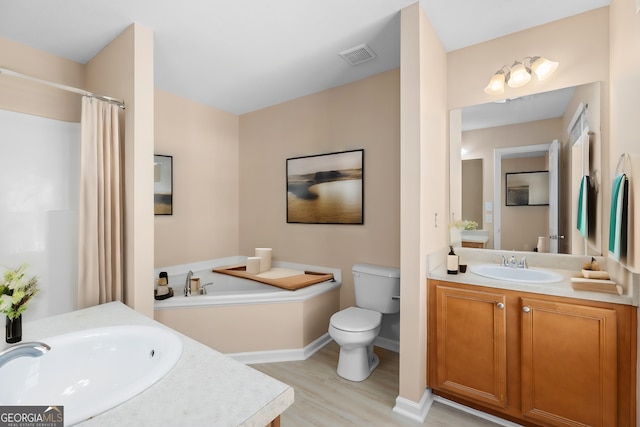 bathroom with wood-type flooring, vanity, toilet, and a tub