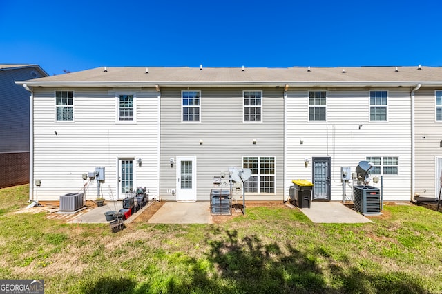 back of property with central air condition unit, a patio, and a lawn