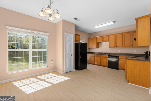 kitchen with pendant lighting, sink, black appliances, an inviting chandelier, and light wood-type flooring