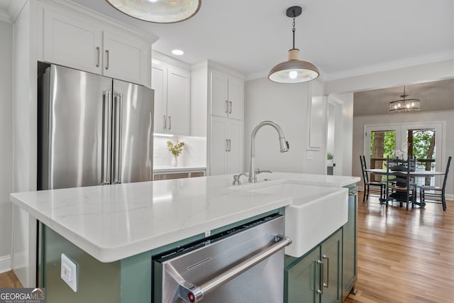 kitchen with white cabinets, green cabinetry, stainless steel appliances, and a kitchen island with sink