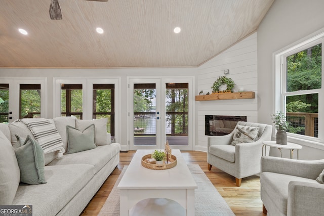 living room featuring french doors, vaulted ceiling, and a healthy amount of sunlight