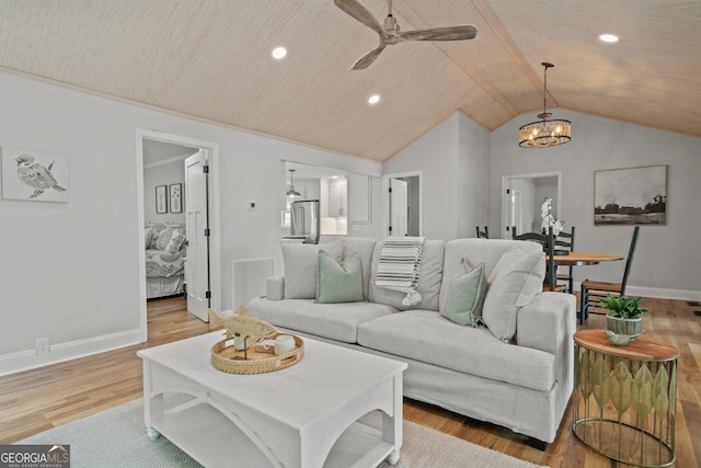 living room featuring lofted ceiling, ceiling fan with notable chandelier, and light hardwood / wood-style flooring