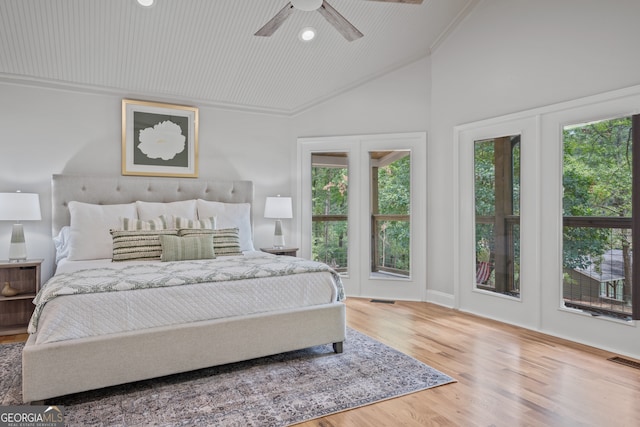 bedroom with access to outside, hardwood / wood-style floors, multiple windows, and ceiling fan