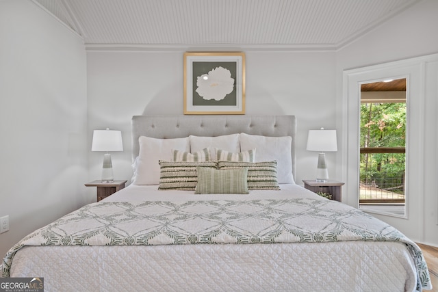 bedroom with hardwood / wood-style flooring, lofted ceiling, crown molding, and multiple windows