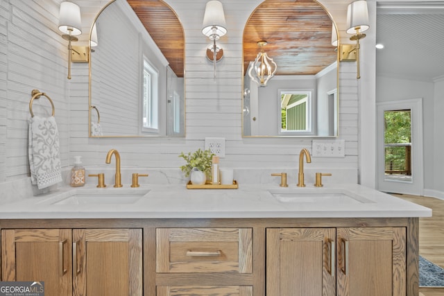 bathroom featuring vanity, wooden walls, ornamental molding, and wooden ceiling