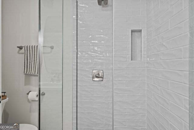 bathroom featuring a shower with door