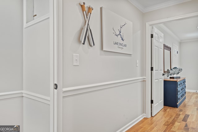 hall with ornamental molding and light hardwood / wood-style floors