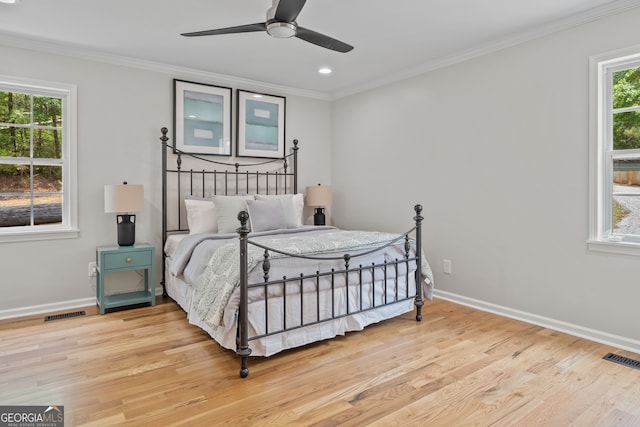 bedroom with wood-type flooring, multiple windows, and ceiling fan