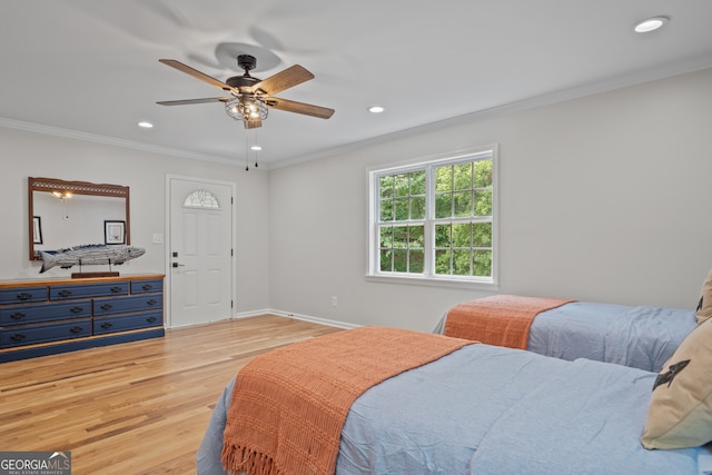 bedroom featuring light wood-type flooring, crown molding, and ceiling fan