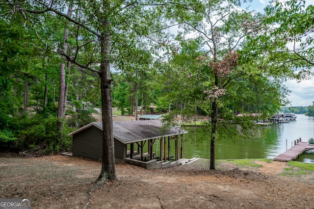 view of side of property with a water view and a dock