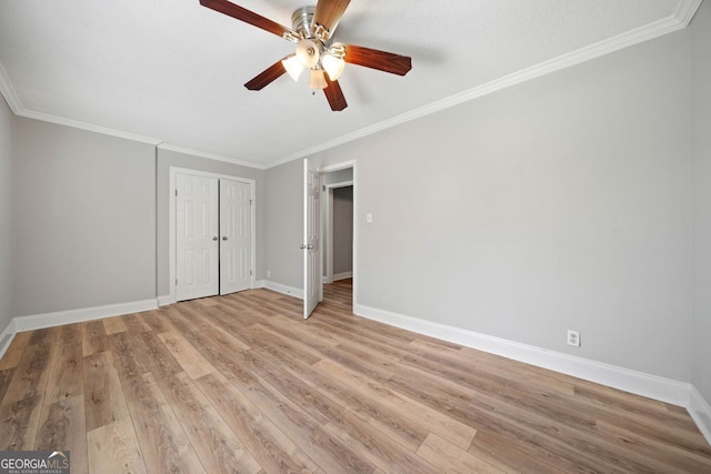 unfurnished bedroom with crown molding, a textured ceiling, light wood-type flooring, and ceiling fan