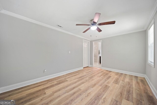 empty room with light hardwood / wood-style floors, crown molding, and ceiling fan